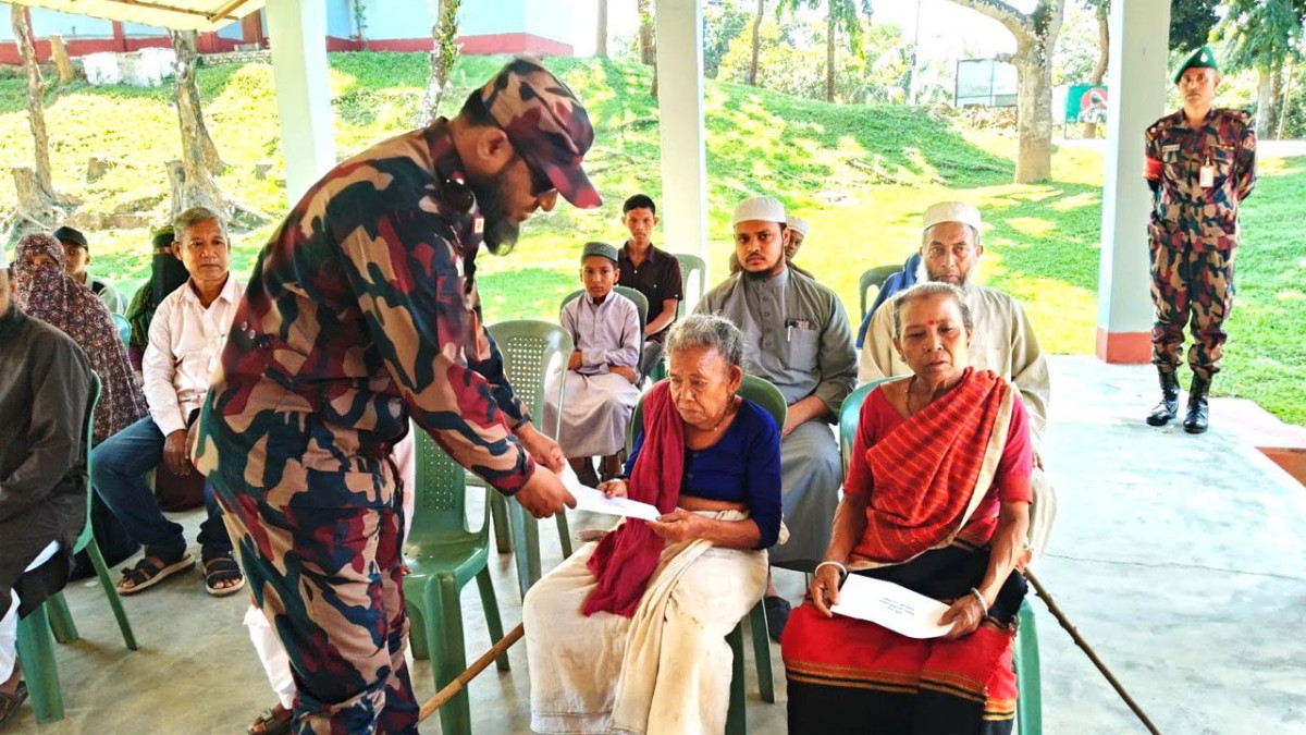 পরিবারের মাঝে আর্থিক সহায়তা তুলে দিচ্ছেন বিজিবি সদস্য